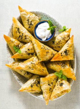 Baharatlı patates ve sebzelerle yapılmış Hint samosası yoğurt, nane ve limonla servis ediliyor. Reklam için kapatıyoruz.