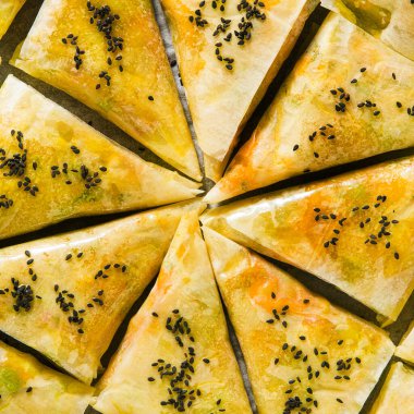 Baharatlı patates ve sebzeli Hint samosası. Fırında siyah susam tohumlarıyla pişirilmeye hazır.