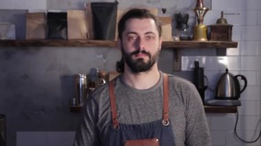 Beyaz barista önlük giyen ve bar veya kahvehane içinde duran portre.