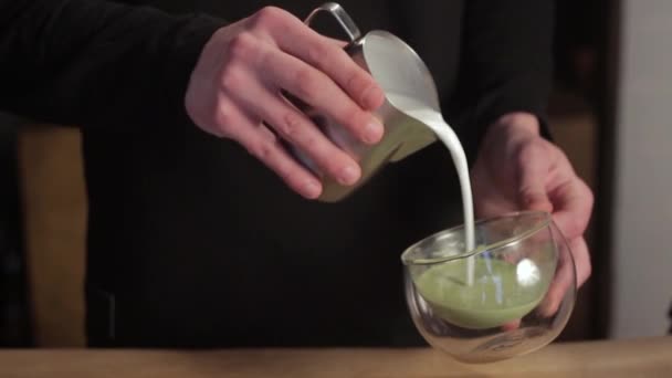 Mão masculina preparando chá verde Matcha com leite. Barista fazendo arte latte . — Vídeo de Stock