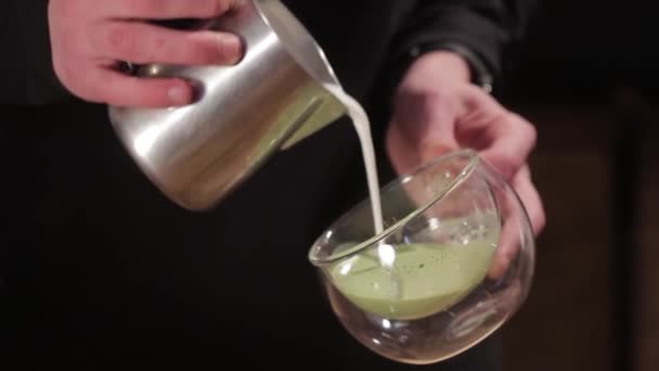 Mano masculina preparando té verde Matcha con leche. Barista haciendo arte latte . — Vídeos de Stock