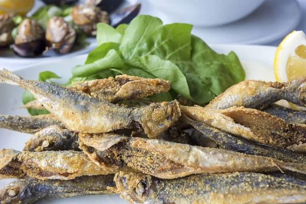 Limonlu ve yeşil yapraklı ızgara balık.