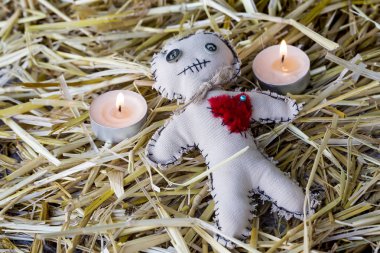 voodoo doll with candles on the straw