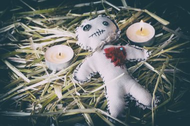 voodoo doll with candles on the straw