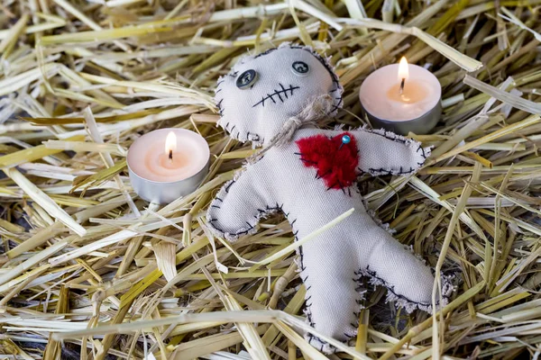 voodoo doll with candles on the straw