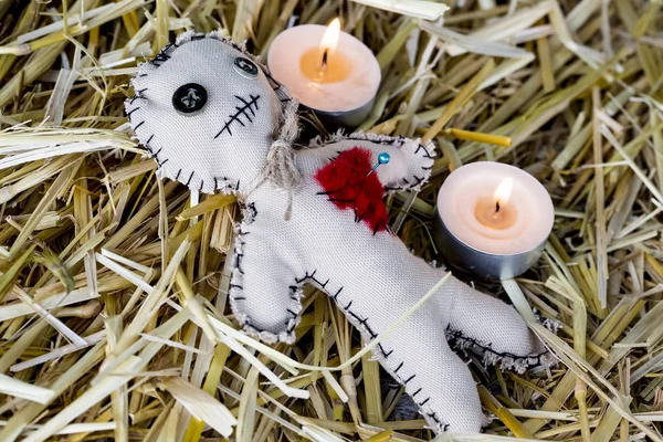 voodoo doll with candles on the straw