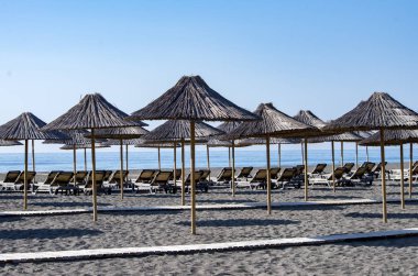 beach view with straw umbrellas and blue sky.