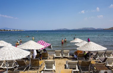 beach with umbrellas, people resting on the seaside