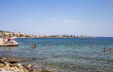 beach with umbrellas, people resting on the seaside
