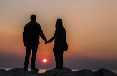 Gün batımında sahilde bir çift.