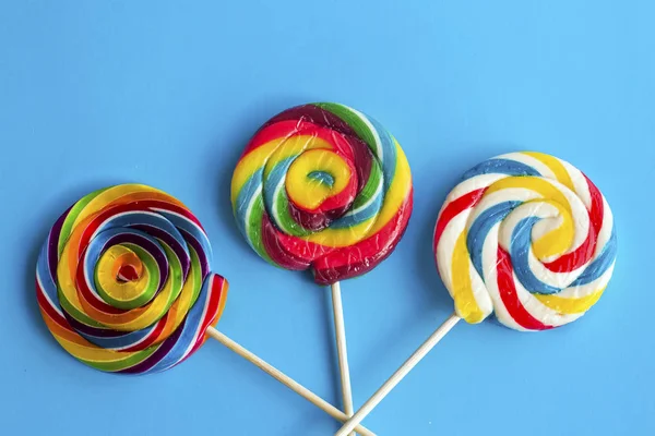 colorful lollipop sticks on blue background