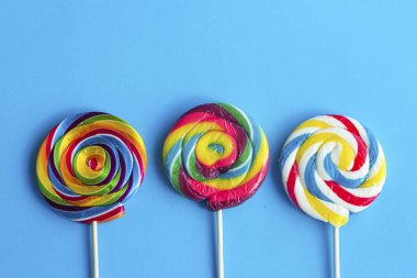 Mavi arka planda renkli lolipop çubukları