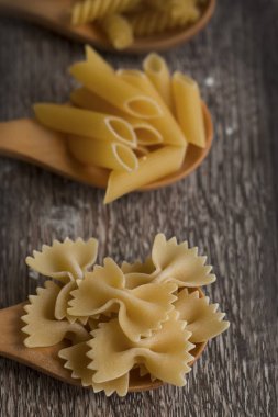 Tahta kaşıklarda çiğ makarna.