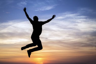 silhouette of jumping man against sunset