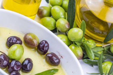 Yeşil zeytin ve zeytinyağı arka planda