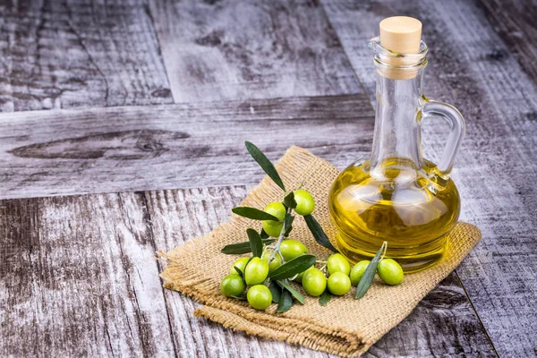 Green Olive and olive oil on the background