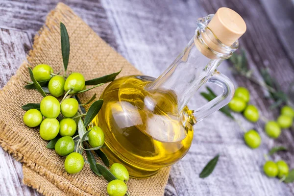 Green Olive and olive oil on the background