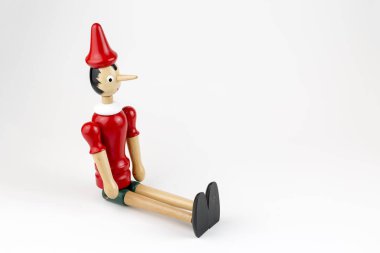 Beyaz arka plan üzerinde izole ahşap Pinokyo Bebek oturma.