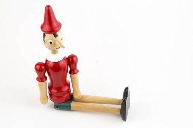 Beyaz arka plan üzerinde izole ahşap Pinokyo Bebek oturma.