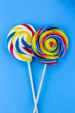 Renkli lolipoplar ve farklı renkte yuvarlak şekerler. Üst görünüm.
