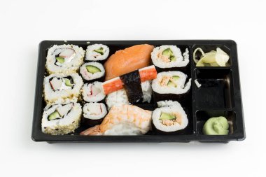 Suşi, beyaz arka planda izole edilmiş Japon yemeklerini yuvarlıyor.. 