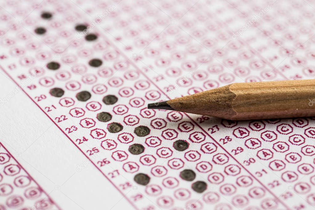 Exams quiz test paper with pencil drawing selected choice on answer sheets at school