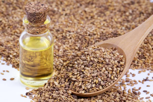 Bottle of sesame oil and sesame seeds isolated