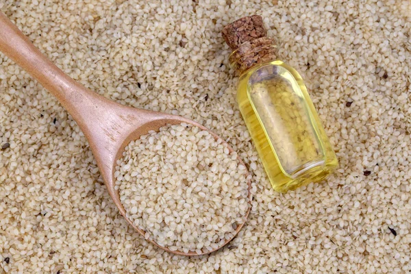 Bottle of sesame oil and sesame seeds isolated