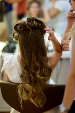 Saç stilisti ya da çiçekçi gelin düğün saç modeli yapar