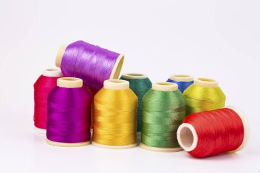 Beyaz arkaplanda renkli iplik bobinleri, dikiş, metin için yer
