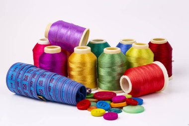Beyaz arkaplanda renkli iplik bobinleri, dikiş, metin için yer
