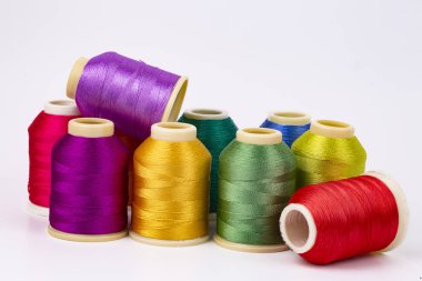 Beyaz arkaplanda renkli iplik bobinleri, dikiş, metin için yer
