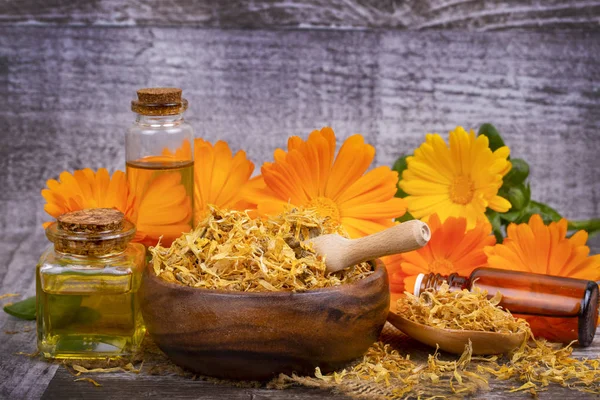 Calêndula officinalis ervas no vidro e óleo de gota isolado — Fotografia de Stock