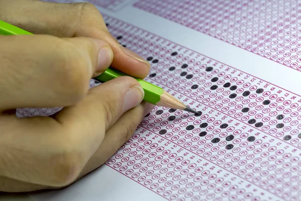 Estudantes fazendo exames, escrevendo sala de exame com caneta de retenção — Fotografia de Stock