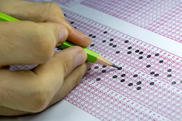 Estudiantes tomando exámenes, escribiendo sala de examen con la celebración de la pluma — Foto de Stock