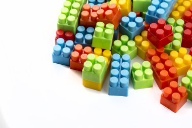 Çocuk oyuncakları; beyaz arkaplanda renkli plastik bloklar.