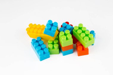 Çocuk oyuncakları; beyaz arkaplanda renkli plastik bloklar.