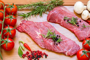 Koyu ahşap bir tahtanın üzerinde çiğ et. Üst görünüm