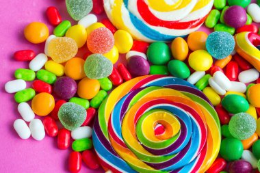 Renkli lolipoplar ve farklı renkte yuvarlak şekerler. Üst görünüm.