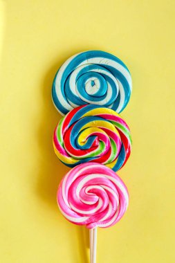 Renkli lolipoplar ve farklı renkte yuvarlak şekerler. Üst görünüm.