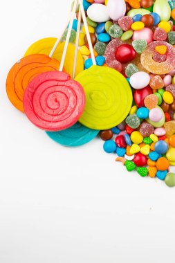 Renkli lolipoplar ve farklı renkte yuvarlak şekerler. Üst görünüm.