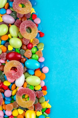 Renkli lolipoplar ve farklı renkte yuvarlak şekerler. Üst görünüm.