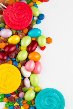 Renkli lolipoplar ve farklı renkte yuvarlak şekerler. Üst görünüm.