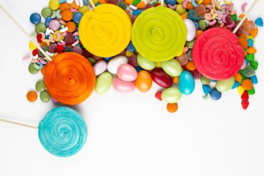 Renkli lolipoplar ve farklı renkte yuvarlak şekerler. Üst görünüm.