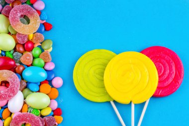 Renkli lolipoplar ve farklı renkte yuvarlak şekerler. Üst görünüm.