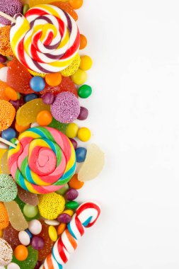 Renkli lolipoplar ve farklı renkte yuvarlak şekerler. Üst görünüm.