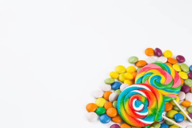 Renkli lolipoplar ve farklı renkte yuvarlak şekerler. Üst görünüm.