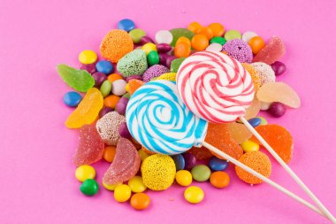 Renkli lolipoplar ve farklı renkte yuvarlak şekerler. Üst görünüm.