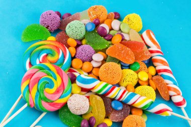 Renkli lolipoplar ve farklı renkte yuvarlak şekerler. Üst görünüm.