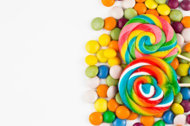 Renkli lolipoplar ve farklı renkte yuvarlak şekerler. Üst görünüm.